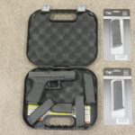 OPEN CASE SHOWING PISTOL AND 3 ORIGINAL AND 3 ADDITIONAL SPARE MAGS